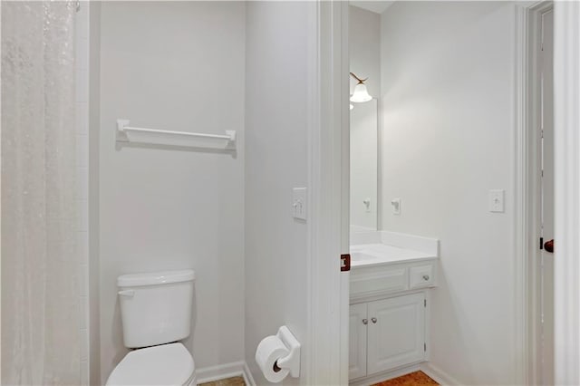 bathroom featuring toilet, vanity, a shower with curtain, and baseboards