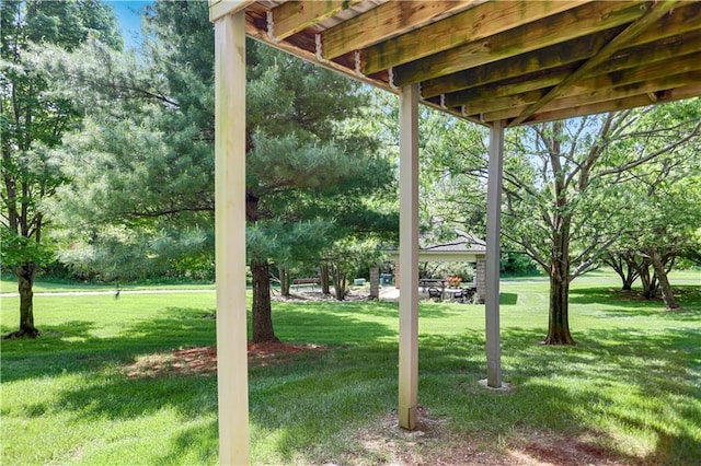 view of green lawn featuring a gazebo and view of wooded area