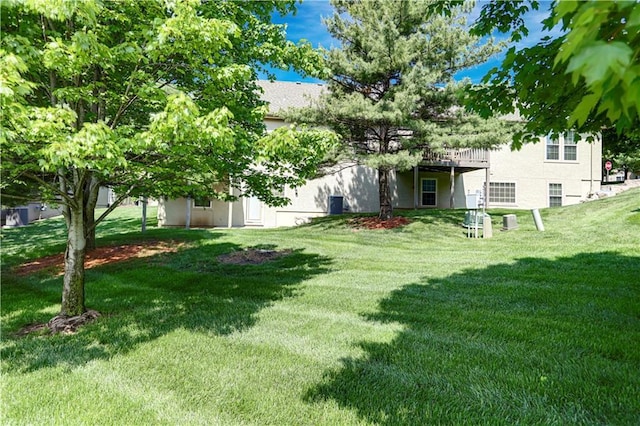 view of green lawn with a deck