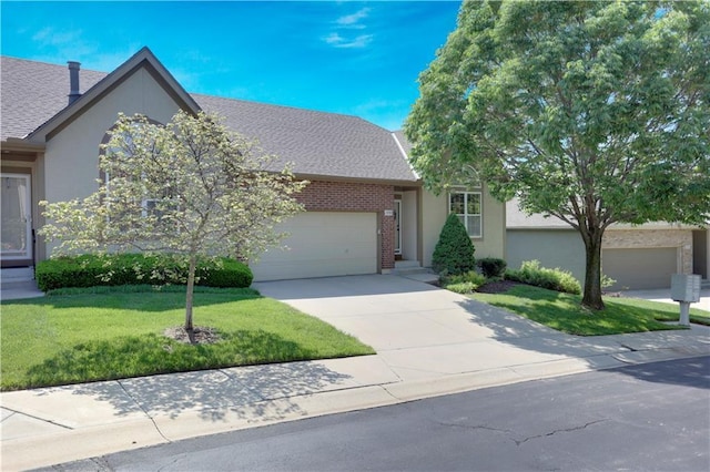 view of front of house with concrete driveway, a garage, a front yard, stucco siding, and brick siding