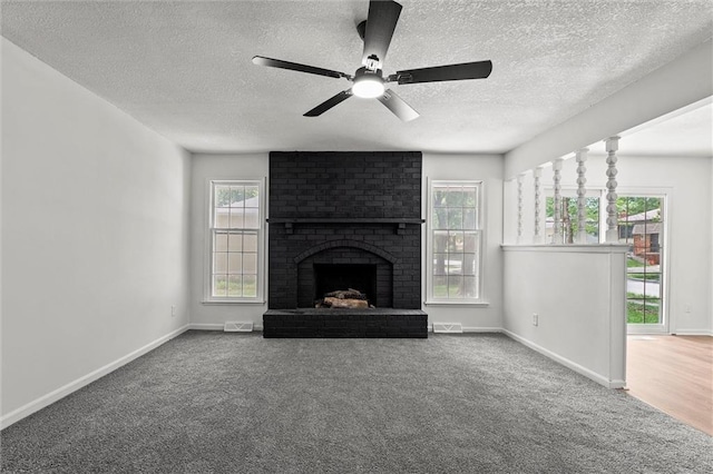 13300 Palmer Ave, Grandview, MO 64030 - unfurnished living room with a textured ceiling, carpet, ceiling fan, and a brick fireplace