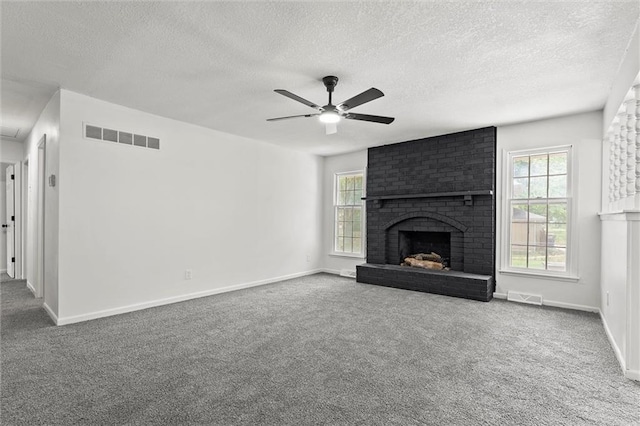13300 Palmer Ave, Grandview, MO 64030 - unfurnished living room with a fireplace, carpet floors, a textured ceiling, and plenty of natural light