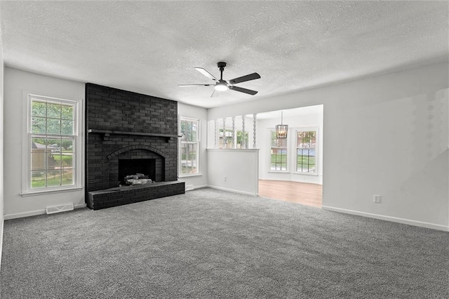 13300 Palmer Ave, Grandview, MO 64030 - unfurnished living room featuring carpet floors, ceiling fan, a brick fireplace, and a textured ceiling