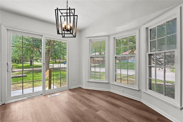 13300 Palmer Ave, Grandview, MO 64030 - unfurnished dining area with a chandelier, dark wood-style flooring, and a textured ceiling