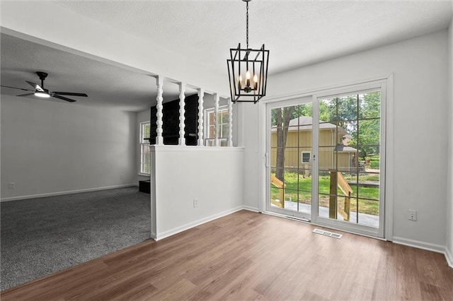 13300 Palmer Ave, Grandview, MO 64030 - unfurnished dining area with a chandelier, healthy amount of natural light, a textured ceiling, wood finished floors, and ceiling fan