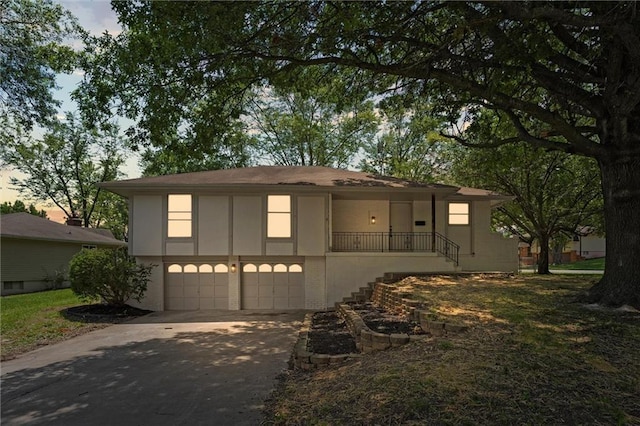 13300 Palmer Ave, Grandview, MO 64030 - view of front of house with an attached garage, driveway, stairway, and stucco siding