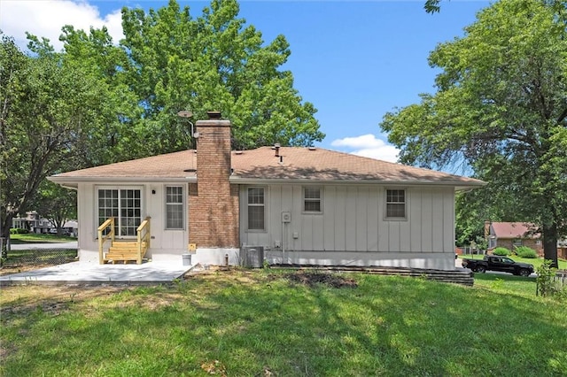 13300 Palmer Ave, Grandview, MO 64030 - back of property featuring a chimney, a yard, a patio, entry steps, and board and batten siding