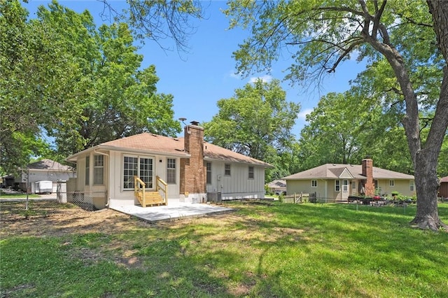 13300 Palmer Ave, Grandview, MO 64030 - rear view of house with entry steps, a patio area, board and batten siding, and a chimney