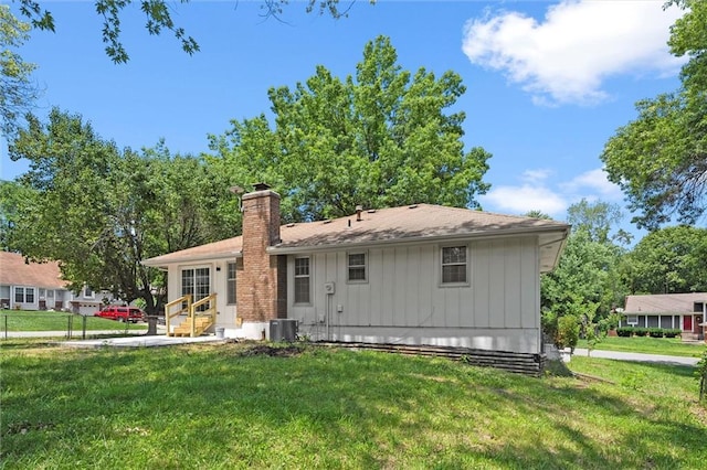 13300 Palmer Ave, Grandview, MO 64030 - back of property with entry steps, a chimney, a yard, and board and batten siding
