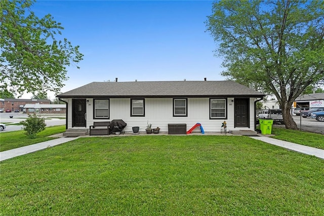 view of front of home with central AC unit and a front yard