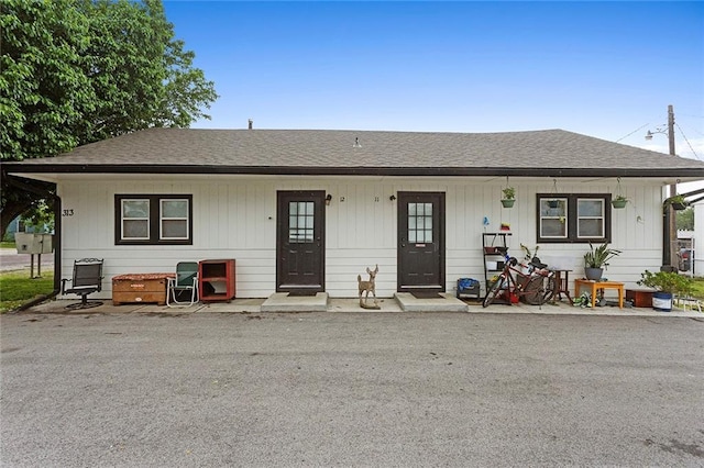 view of front of house with covered porch and a shingled roof