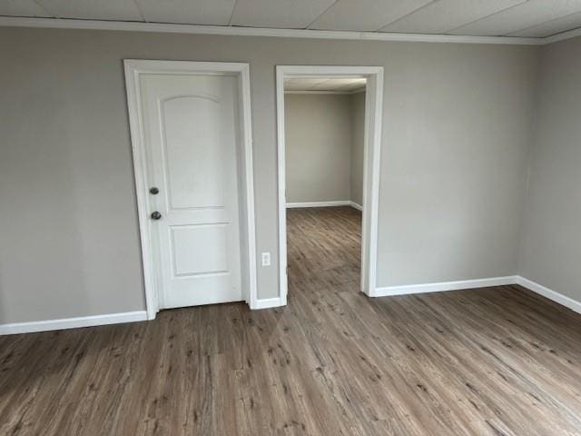 unfurnished bedroom with ornamental molding, baseboards, and wood finished floors