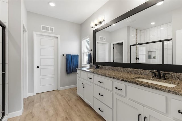 16780 W 170th Ct, Olathe, KS 66062 - bathroom with a shower stall, double vanity, wood finished floors, baseboards, and recessed lighting