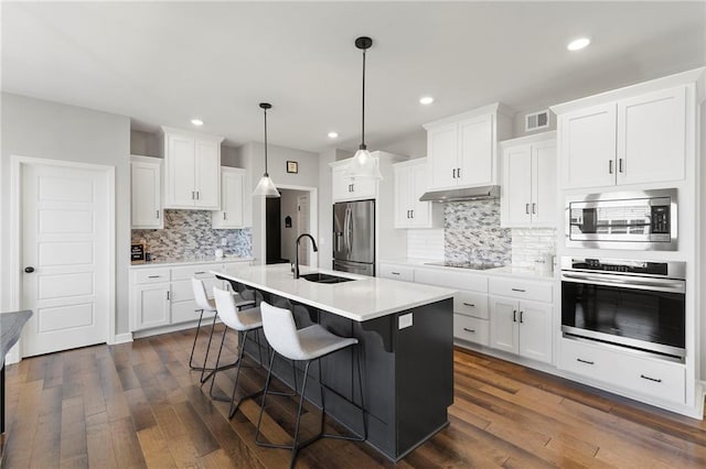 16780 W 170th Ct, Olathe, KS 66062 - kitchen with stainless steel appliances, a sink, under cabinet range hood, dark wood finished floors, and recessed lighting