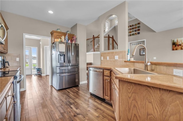 21923 W 116th Pl, Olathe, KS 66061 - kitchen featuring stainless steel appliances, a sink, brown cabinets, wood finished floors, and backsplash