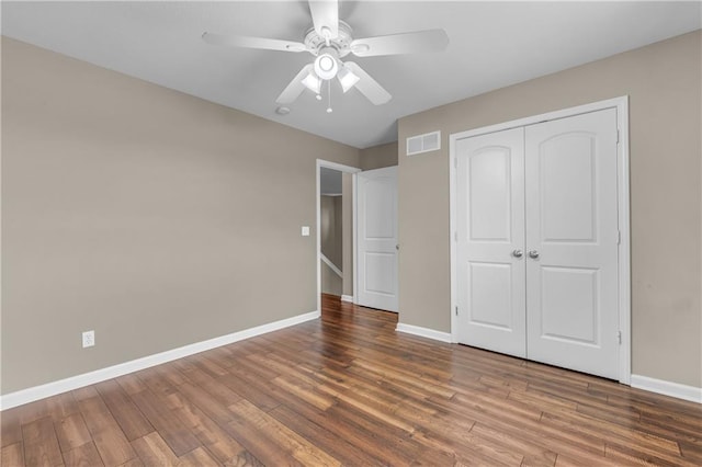 21923 W 116th Pl, Olathe, KS 66061 - unfurnished bedroom featuring baseboards, wood finished floors, a closet, and a ceiling fan