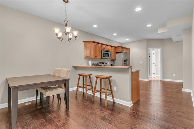 21923 W 116th Pl, Olathe, KS 66061 - kitchen with appliances with stainless steel finishes, a chandelier, dark wood finished floors, recessed lighting, and baseboards