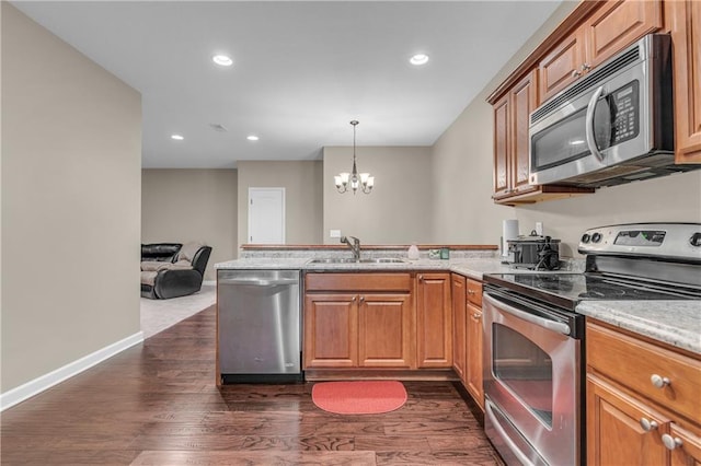 21923 W 116th Pl, Olathe, KS 66061 - kitchen with stainless steel appliances, a sink, a peninsula, a chandelier, and dark wood-type flooring