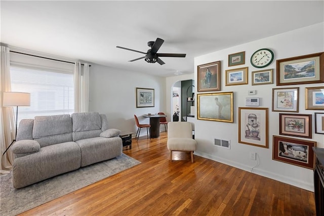 831 E 25th Ave, North Kansas City, MO 64116 - living area with arched walkways, baseboards, wood finished floors, and a ceiling fan