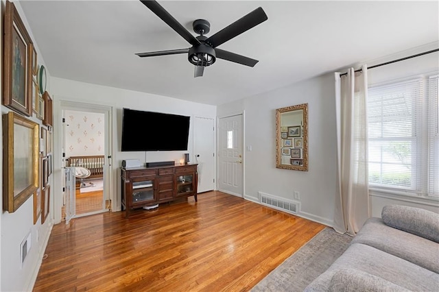 831 E 25th Ave, North Kansas City, MO 64116 - living room with a ceiling fan, light wood-style floors, and baseboards