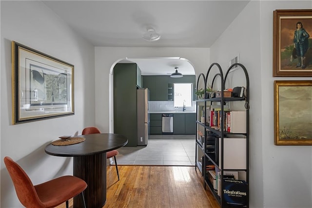 831 E 25th Ave, North Kansas City, MO 64116 - hallway with a sink, light wood finished floors, and arched walkways