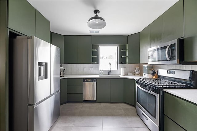 831 E 25th Ave, North Kansas City, MO 64116 - kitchen featuring appliances with stainless steel finishes, green cabinetry, a sink, light countertops, and open shelves