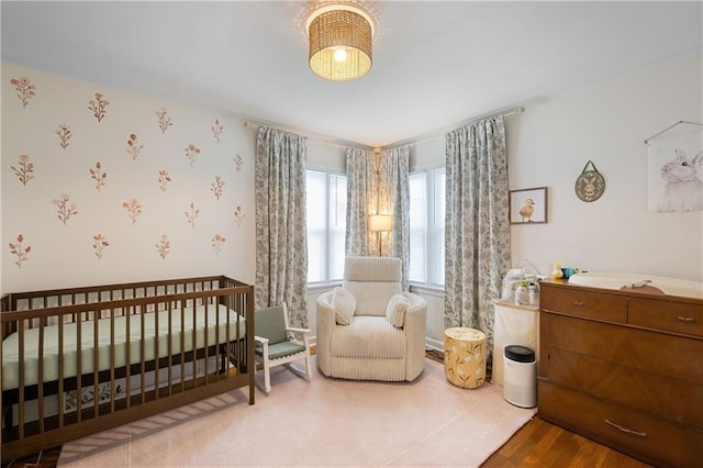 831 E 25th Ave, North Kansas City, MO 64116 - bedroom featuring a nursery area and wood finished floors