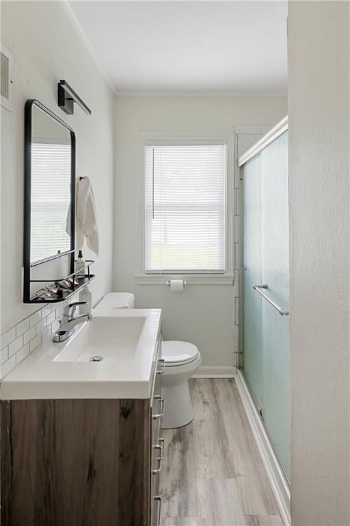 831 E 25th Ave, North Kansas City, MO 64116 - full bath featuring toilet, vanity, wood finished floors, and a stall shower