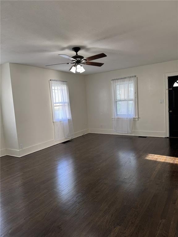 empty room with healthy amount of natural light, ceiling fan, and baseboards