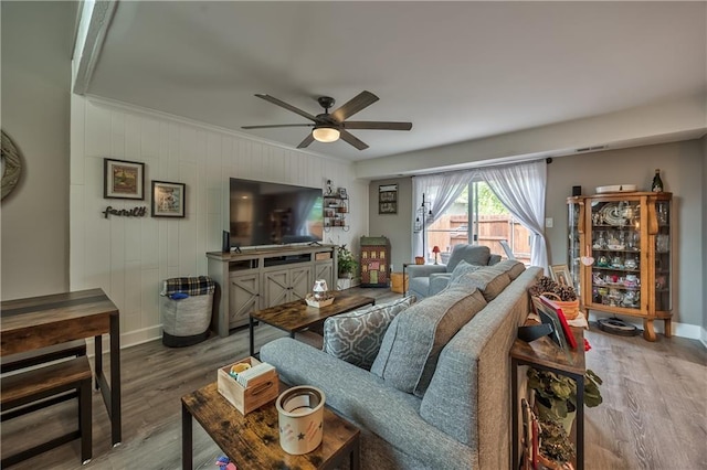 12735 W 108th Pl, Overland Park, KS 66210 - living room featuring a ceiling fan, wood finished floors, baseboards, wood walls, and crown molding