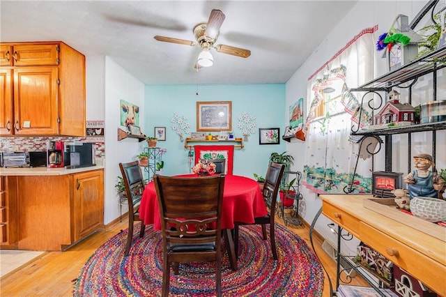 603 W 30th St, Higginsville, MO 64037 - dining area with a wood stove, light wood-type flooring, and ceiling fan