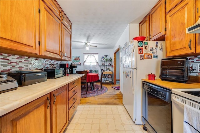 603 W 30th St, Higginsville, MO 64037 - kitchen featuring white appliances, light countertops, brown cabinets, light floors, and tasteful backsplash