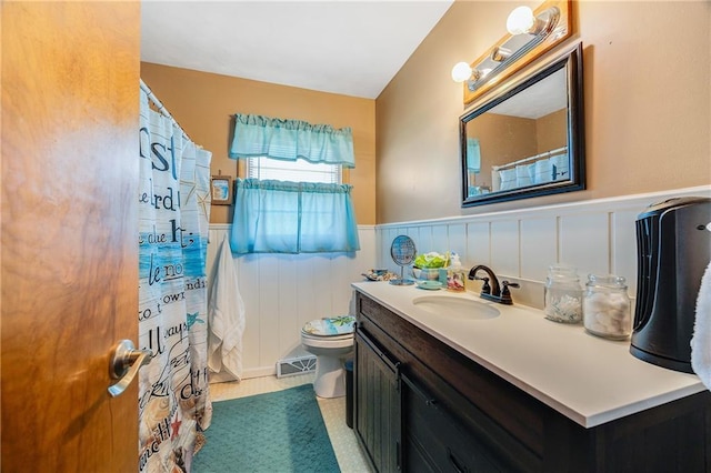 603 W 30th St, Higginsville, MO 64037 - bathroom featuring wainscoting, vanity, toilet, a shower with curtain, and a decorative wall