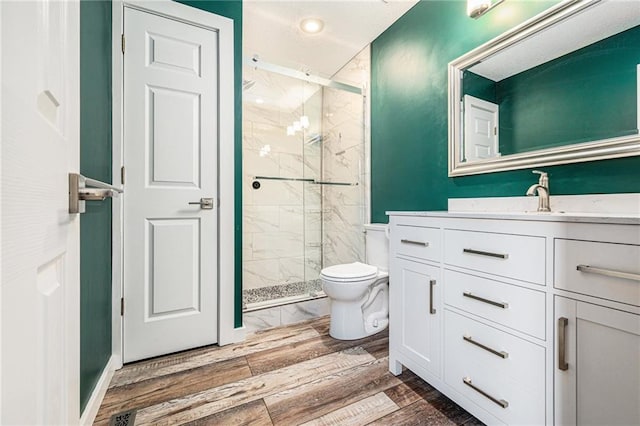 full bathroom featuring toilet, a marble finish shower, vanity, and recessed lighting