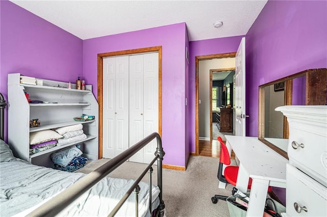 carpeted bedroom featuring a closet and baseboards