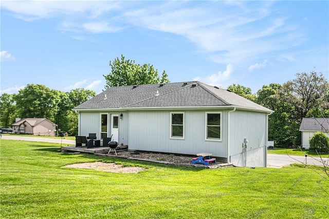 back of house with a lawn and a shingled roof