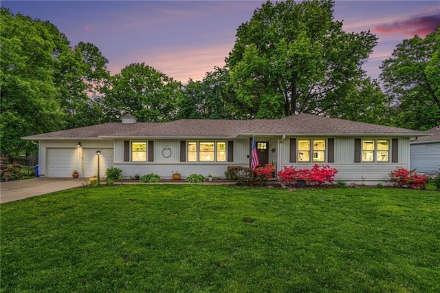 single story home featuring a garage, driveway, and a front lawn