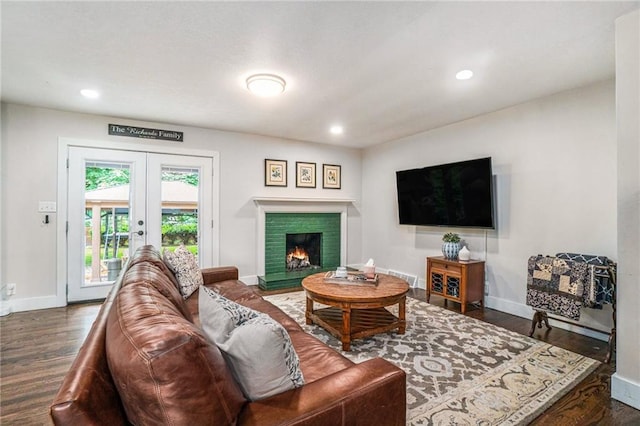 living area featuring baseboards, recessed lighting, french doors, and a warm lit fireplace
