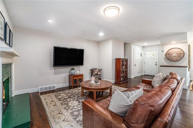 living area with a fireplace, baseboards, wood finished floors, and recessed lighting