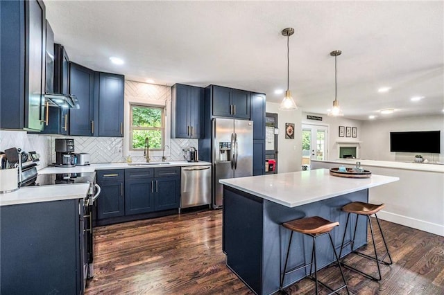 kitchen with a sink, stainless steel appliances, light countertops, tasteful backsplash, and healthy amount of natural light