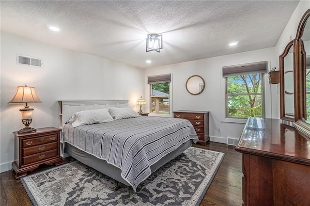 bedroom featuring dark wood-style flooring, a textured ceiling, baseboards, and recessed lighting