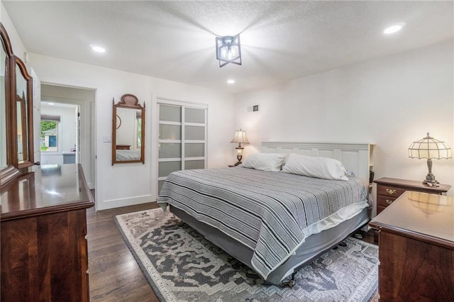 bedroom featuring dark wood-type flooring, recessed lighting, baseboards, and a closet