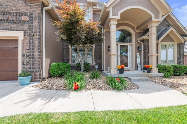 8129 Clearwater Pt, Parkville, MO 64152 - doorway to property featuring stucco siding and a garage