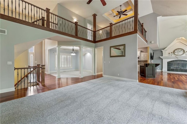 8129 Clearwater Pt, Parkville, MO 64152 - unfurnished living room with carpet flooring, a high ceiling, ceiling fan, and wood finished floors