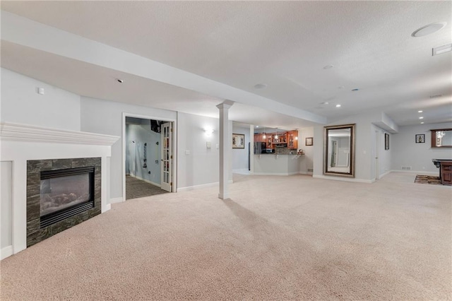 8129 Clearwater Pt, Parkville, MO 64152 - unfurnished living room featuring a glass covered fireplace, light carpet, and a textured ceiling