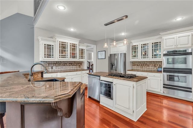 8129 Clearwater Pt, Parkville, MO 64152 - kitchen featuring appliances with stainless steel finishes, a warming drawer, decorative backsplash, a peninsula, and recessed lighting