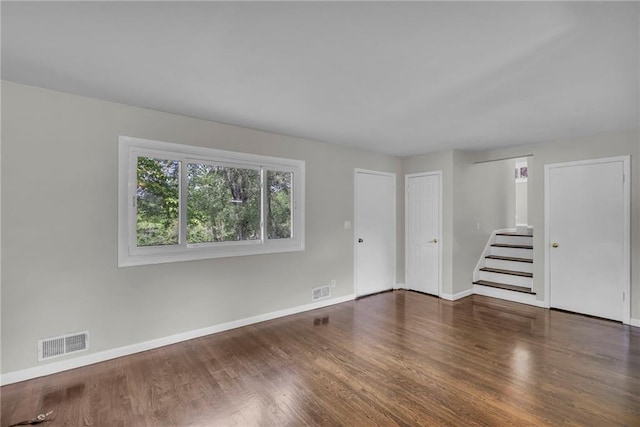4203 E 113th St, Kansas City, MO 64137 - spare room featuring baseboards, stairway, and wood finished floors