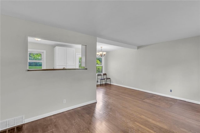 4203 E 113th St, Kansas City, MO 64137 - unfurnished room with a chandelier, baseboards, and wood finished floors