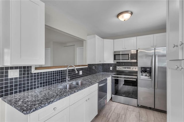 4203 E 113th St, Kansas City, MO 64137 - kitchen with appliances with stainless steel finishes, a sink, white cabinets, and dark stone counters