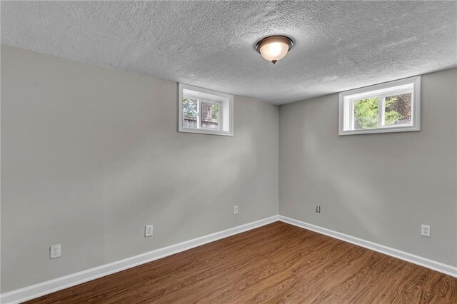 4203 E 113th St, Kansas City, MO 64137 - basement with wood finished floors, baseboards, a textured ceiling, and healthy amount of natural light